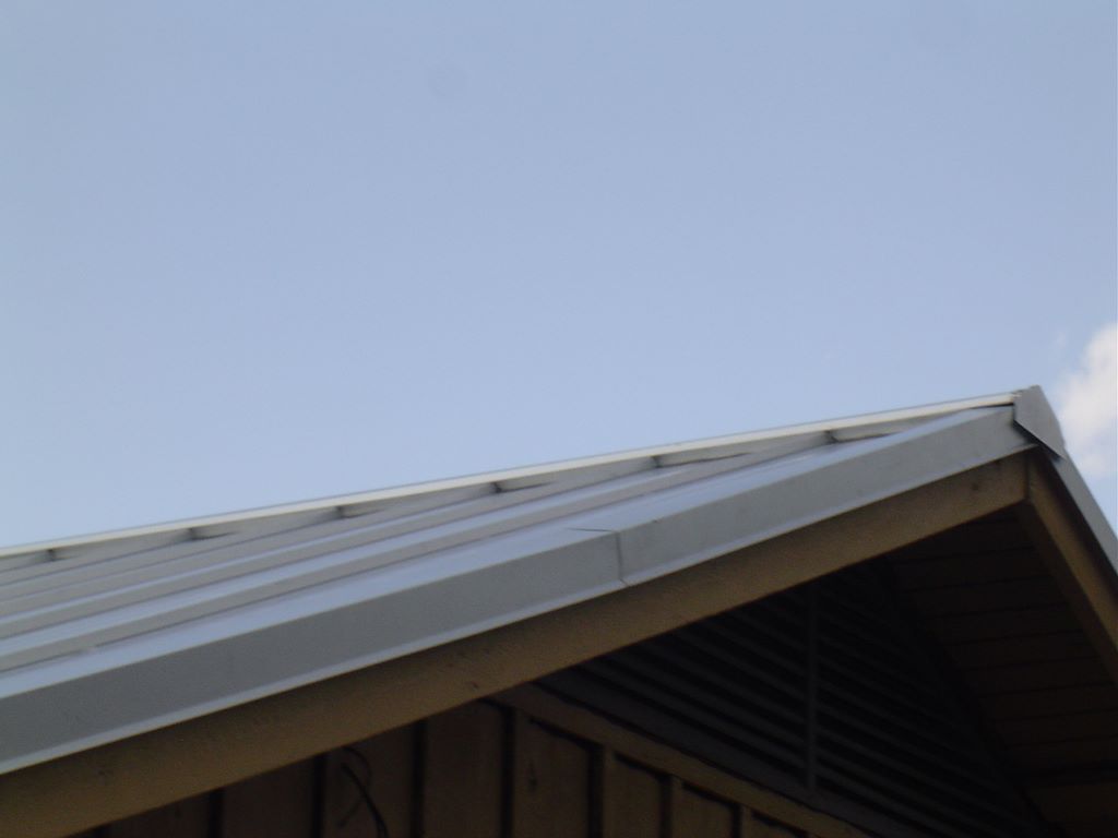 Metal roof panels, ridge, and flashing details on a large building roofed by A Classic Roofing
