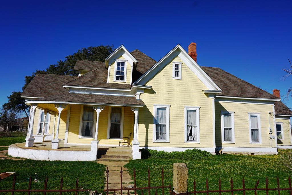 Steep gable roof and porch detail on a historic Texas home roofed by A Classic Roofing